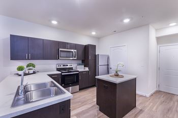A kitchen with a sink, stove, and refrigerator.